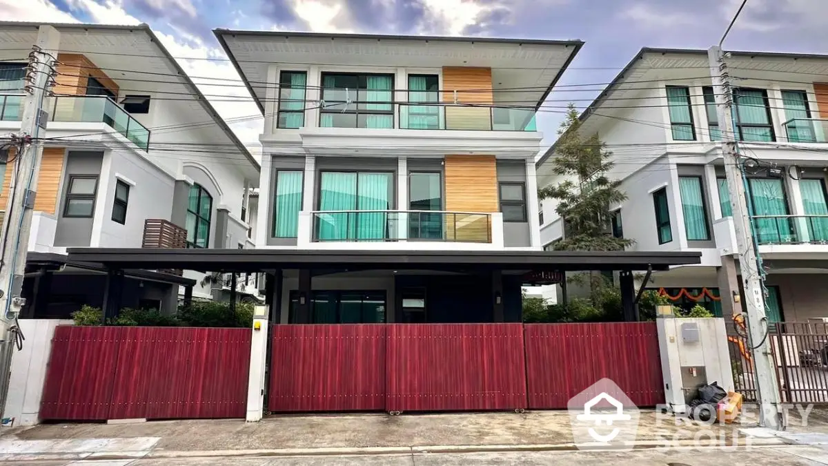 Modern three-story townhouse with sleek design and spacious balconies in a suburban neighborhood.