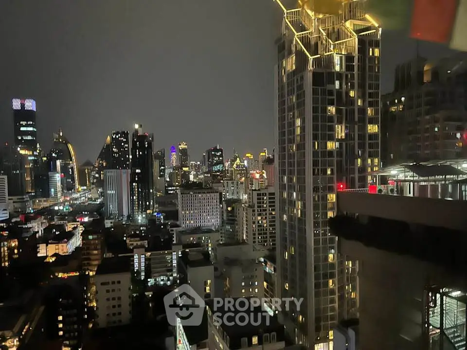 Stunning cityscape view from a high-rise building at night, showcasing vibrant city lights and modern architecture.