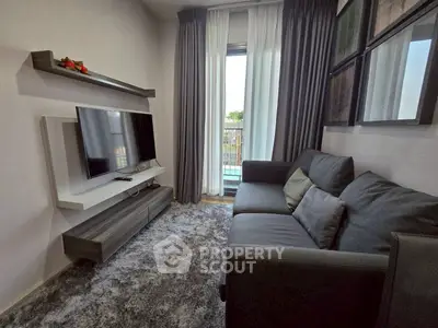 Cozy living room with modern decor and large TV, perfect for relaxation.