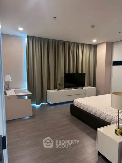 Modern bedroom with sleek furniture and large window curtains