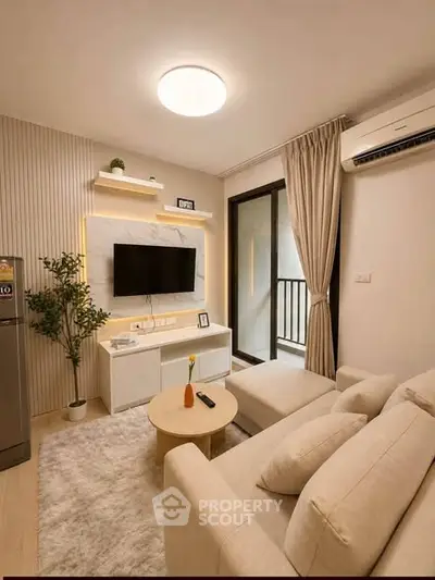 Modern living room with cozy sofa, wall-mounted TV, and balcony access in a stylish apartment.