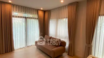 Elegant living room with floor-to-ceiling windows and cozy sofa