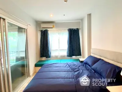 Spacious bedroom with large windows and ample natural light, featuring a comfortable bed and direct access to a private balcony.