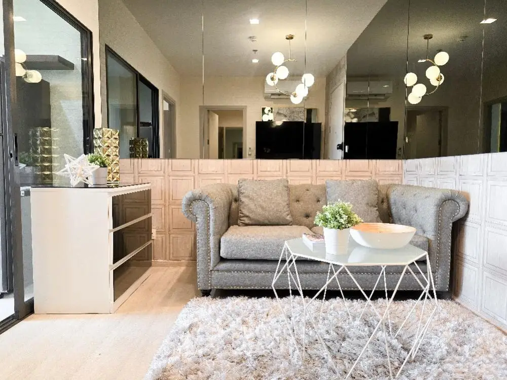 Elegant living room with plush sofa, modern decor, and stylish lighting in a chic apartment.