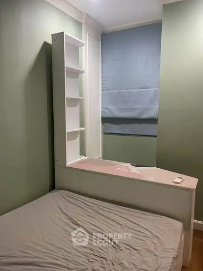 Cozy bedroom with built-in shelving and soft green walls