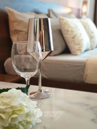 Luxurious bedroom with elegant decor and stylish wine glasses on a marble table.