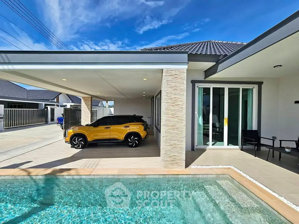 Modern villa with pool and carport under clear blue sky
