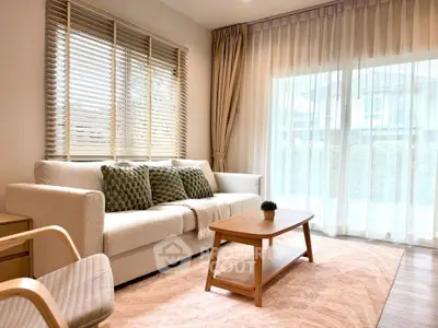 Elegant living room with cozy sofa, wooden coffee table, and large window with sheer curtains.