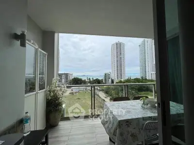 Spacious balcony with dining area offering stunning cityscape views in a modern high-rise apartment.