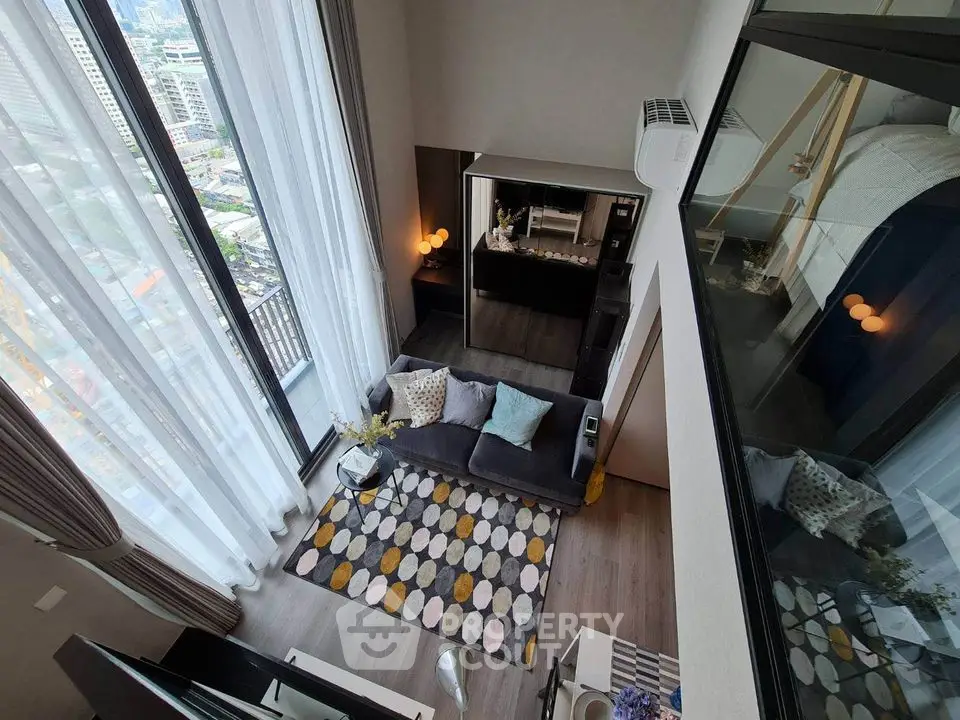 Modern loft apartment with high ceilings and large windows offering city views