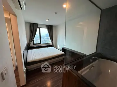 Modern bedroom with city view and luxurious bathtub in a stylish apartment.