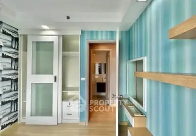 Modern interior with sliding door and stylish wallpaper, featuring built-in storage and sleek wooden shelves.