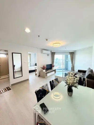 Spacious modern living room with dining area and balcony view in a stylish apartment.