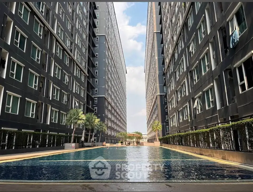 Luxurious modern apartment complex with stunning outdoor pool and sleek architectural design.