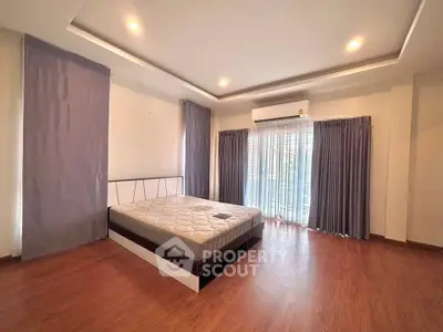 Spacious bedroom with modern design and large windows for natural light.
