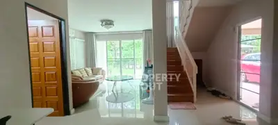 Spacious living room with natural light and modern staircase