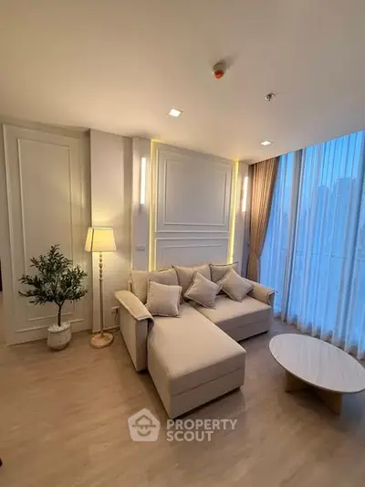 Elegant living room with modern decor and large windows offering city views.