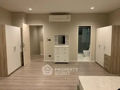 Spacious modern bedroom with sleek wooden flooring and ample storage
