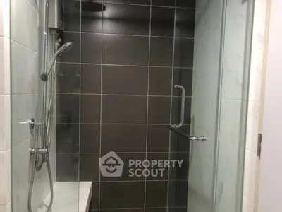 Modern bathroom with sleek glass shower and tiled walls.