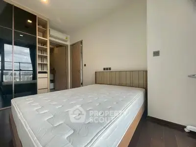 Modern bedroom with large window and built-in closet in a high-rise apartment.