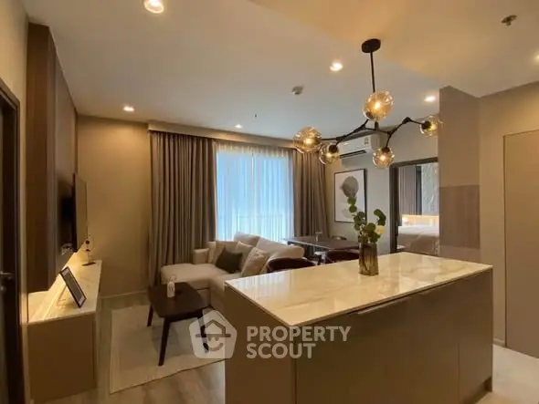 Modern open-layout living room with stylish lighting and cozy seating area, perfect for urban living.