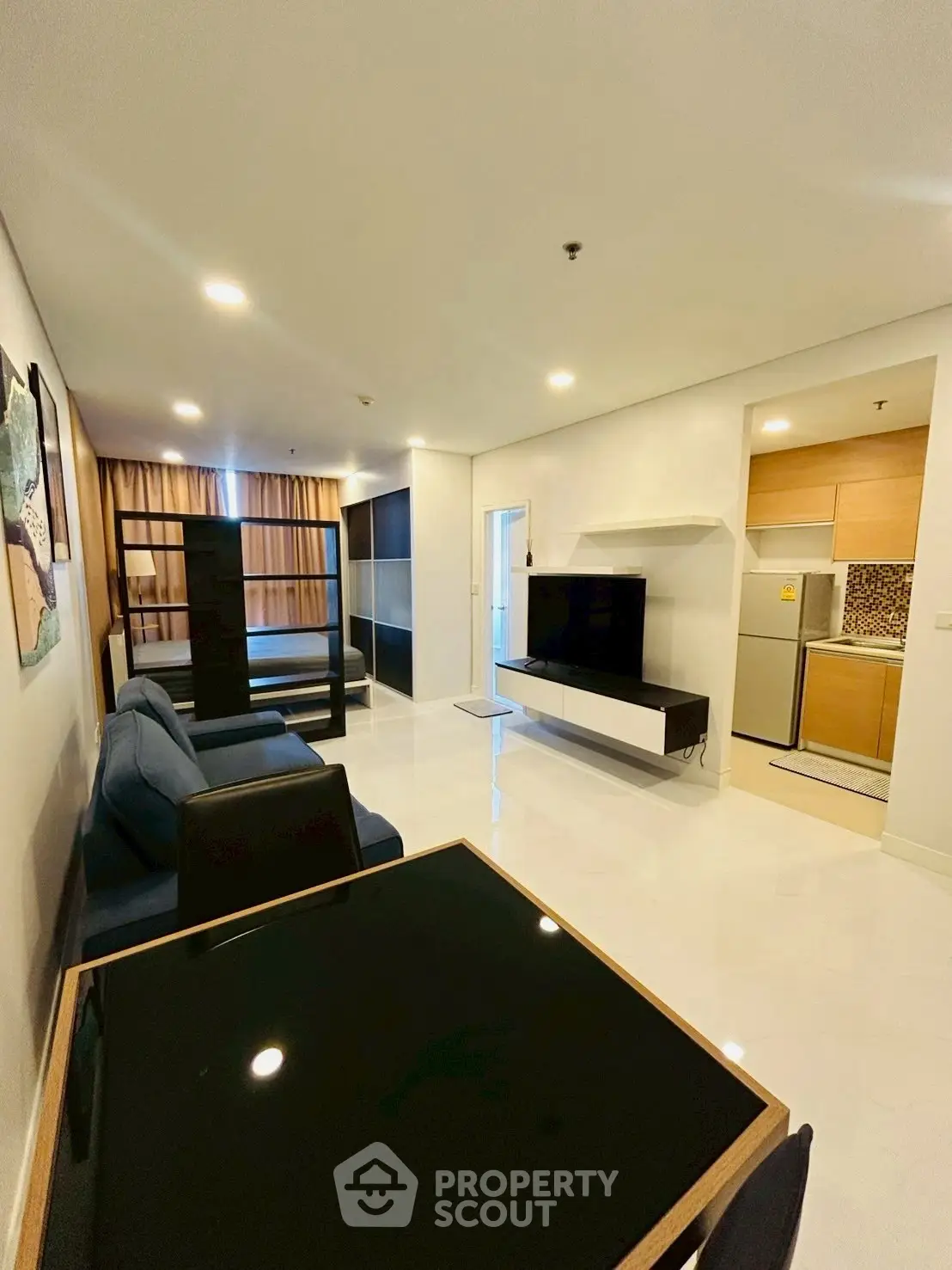 Modern living room with sleek furniture and open kitchen layout in a stylish apartment.