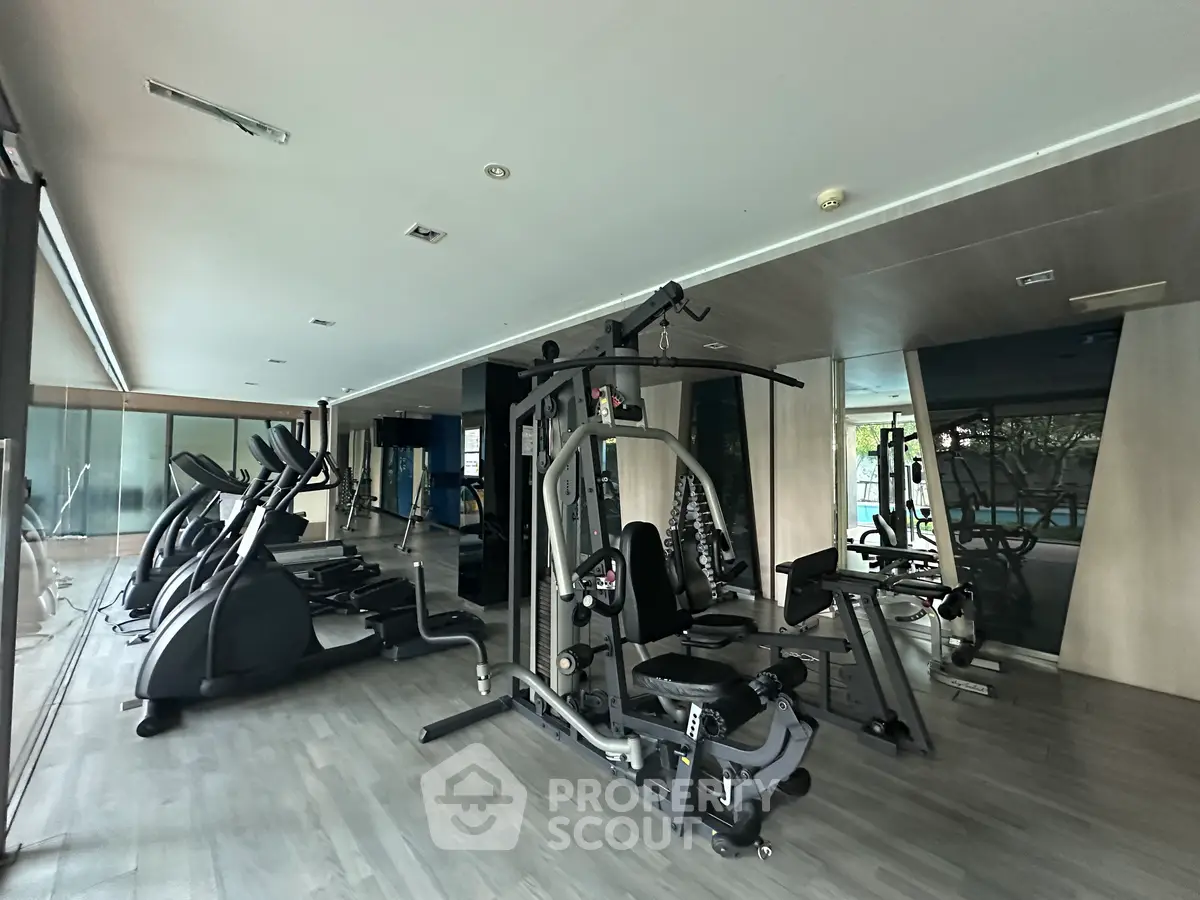 Modern gym with state-of-the-art fitness equipment and mirrored walls in a luxury apartment complex.