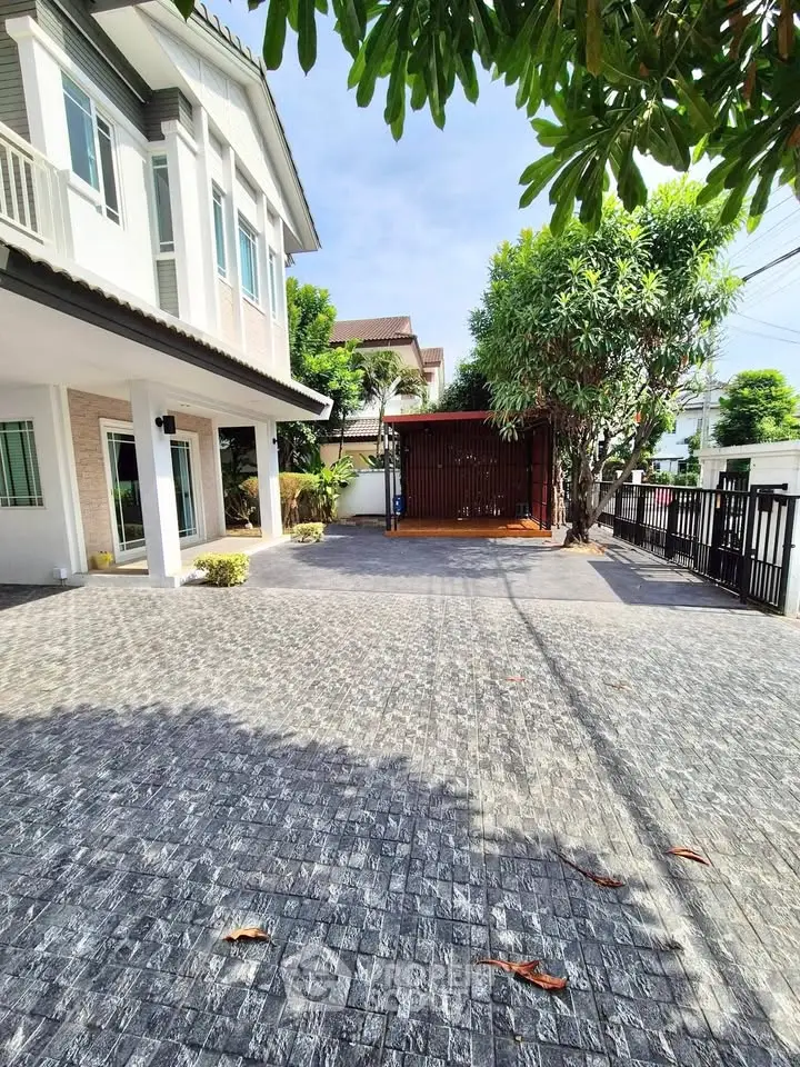Spacious modern house with large driveway and lush greenery, perfect for family living.