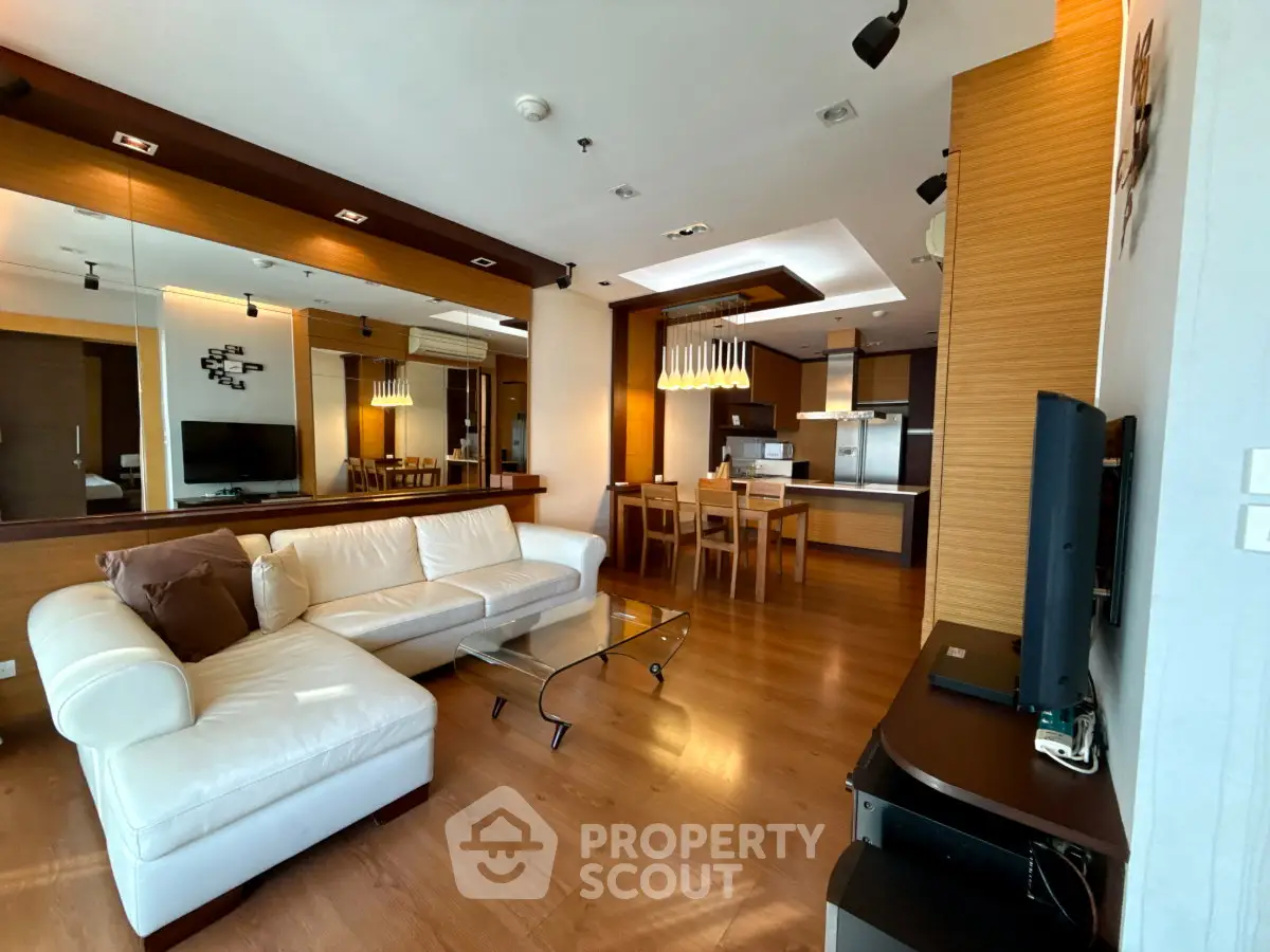 Luxurious open-plan living room with modern kitchen and elegant wooden flooring.