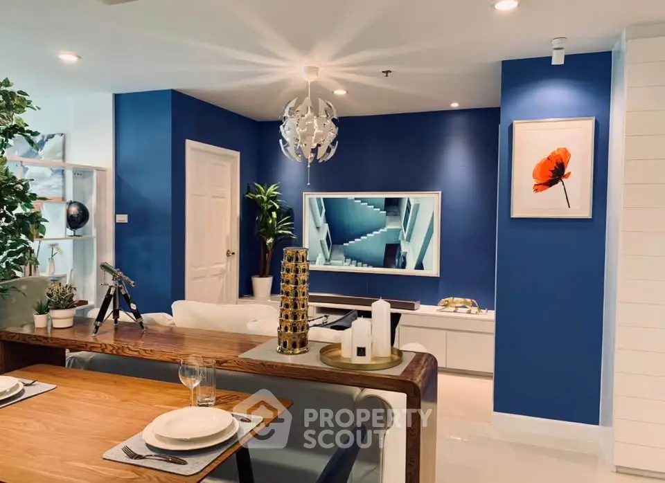 Modern living room with blue accent wall, stylish decor, and elegant dining area.
