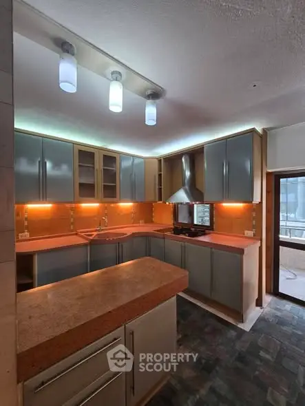 Modern kitchen with sleek cabinets and ambient lighting, featuring a gas stove and spacious countertop.