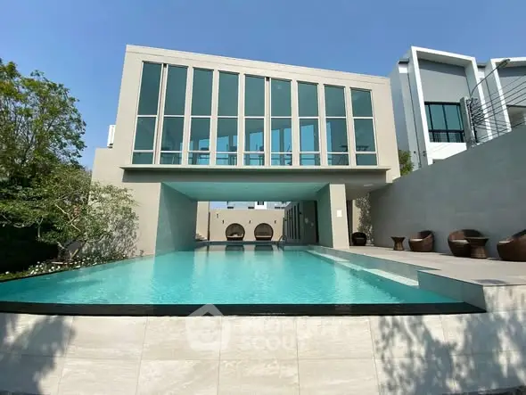 Luxurious modern building with stunning pool and sleek architecture.