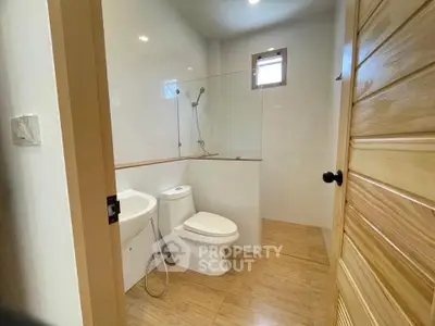 Modern bathroom with wooden accents and glass shower enclosure