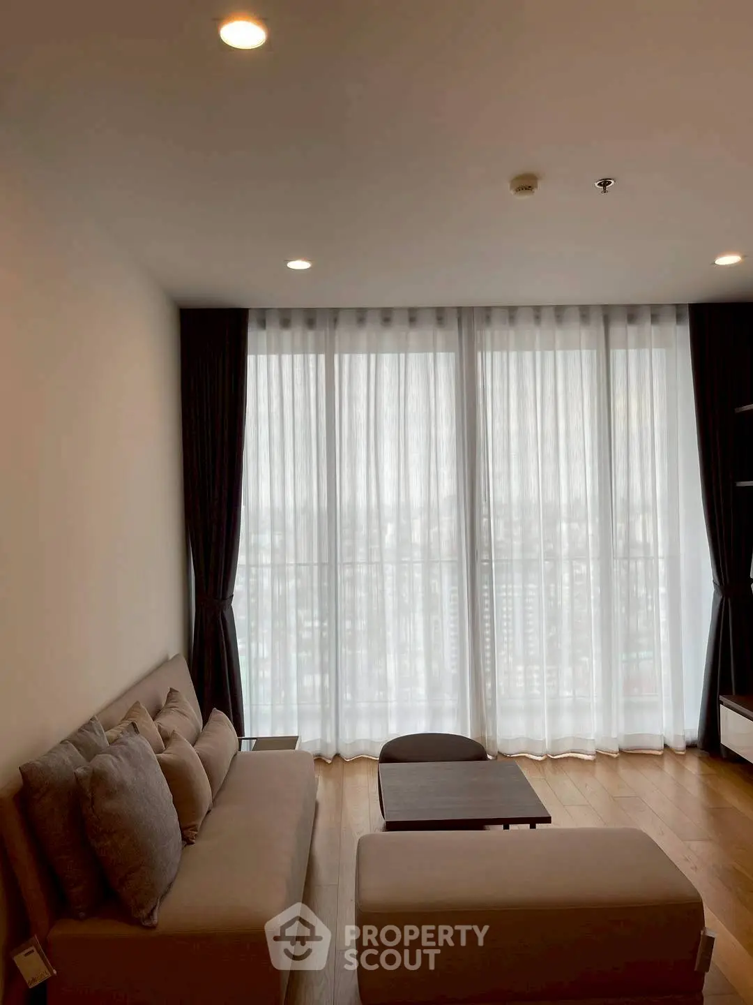 Modern living room with large windows and cozy seating area.