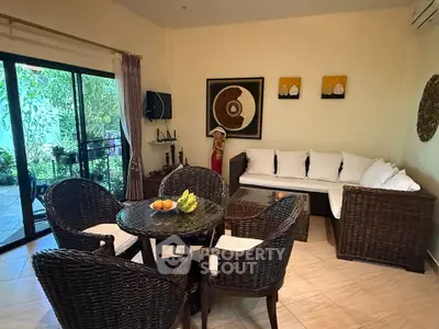 Charming living room with wicker furniture and garden view, perfect for relaxation.