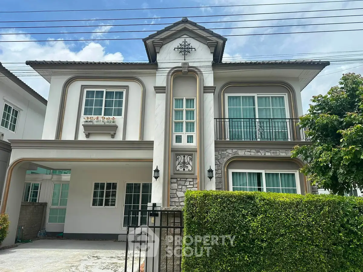Elegant two-story house with classic architecture and lush greenery, perfect for family living.