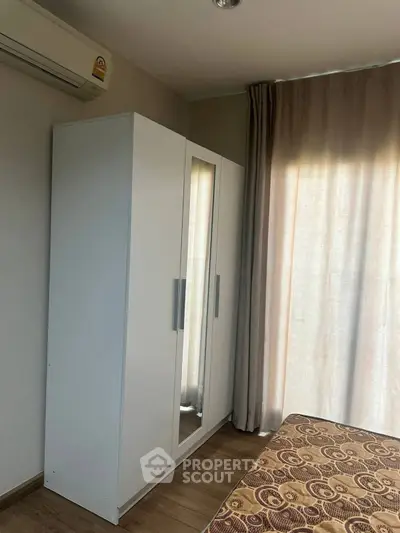 Cozy bedroom with modern wardrobe and air conditioning, perfect for comfortable living.