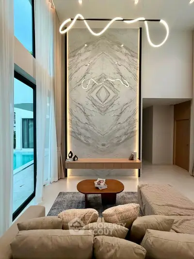 Luxurious living room with high ceilings, modern lighting, and pool view, perfect for elegant living.