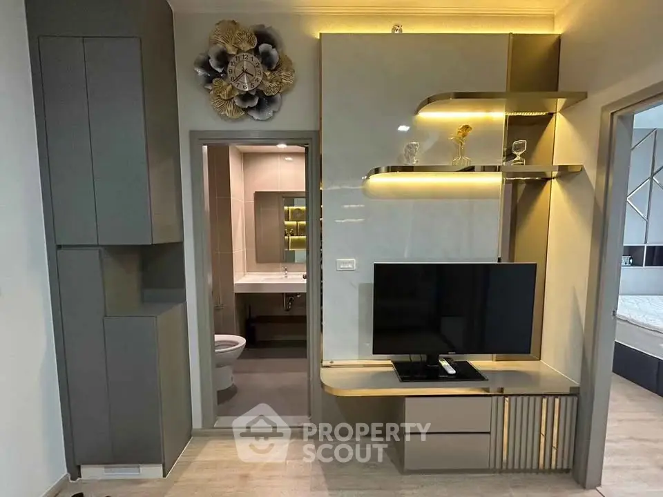 Modern living room with sleek TV unit and bathroom view, showcasing contemporary design and elegant decor.
