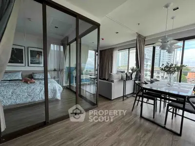 Spacious modern living room with glass partition and dining area, featuring elegant decor and city view.