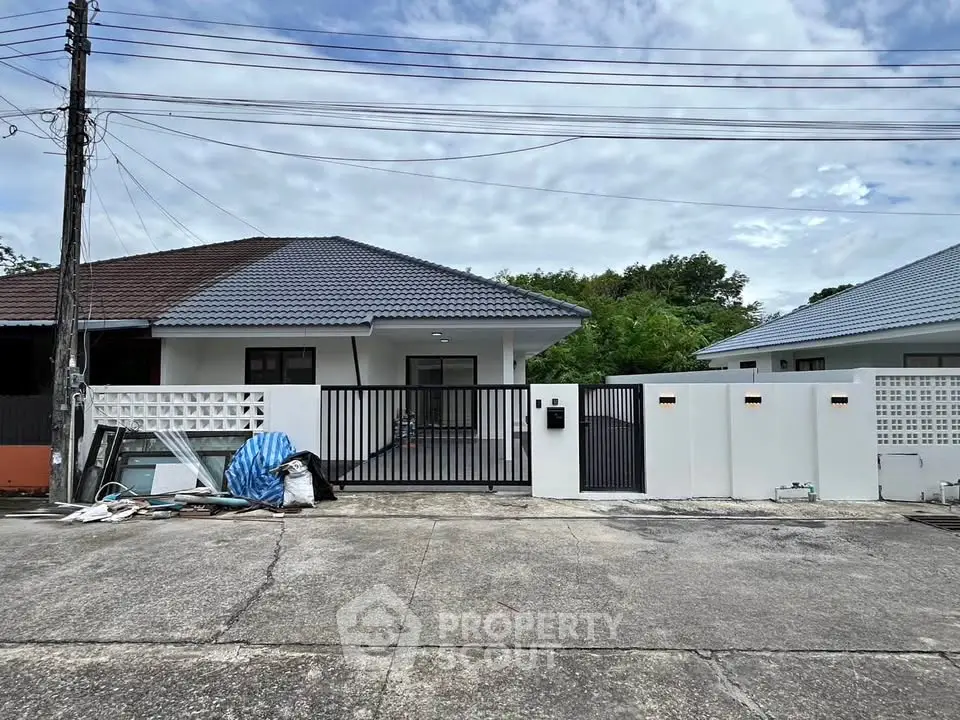 Charming single-story house with modern fence and spacious driveway in a serene neighborhood.