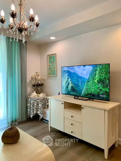 Charming living room with elegant chandelier and modern TV setup, perfect for cozy relaxation.