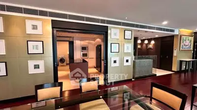 Luxurious open-plan living room with modern kitchen and elegant dining area, featuring stylish decor and hardwood floors.