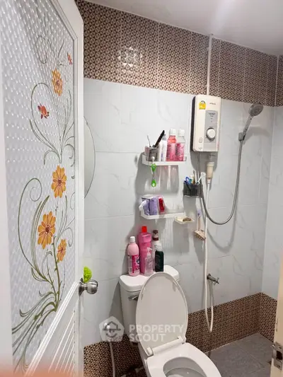 Modern bathroom with floral door design and wall-mounted shower heater.