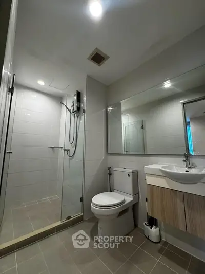 Modern bathroom with glass shower and sleek fixtures in a contemporary apartment.