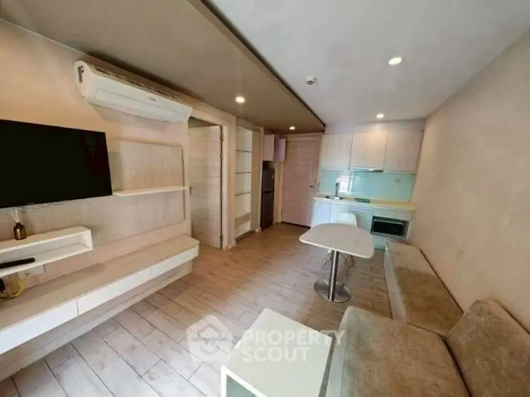 Modern open-layout living room with sleek kitchen and cozy seating area