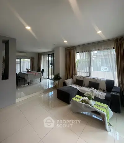 Spacious living room with modern decor and large windows for natural light