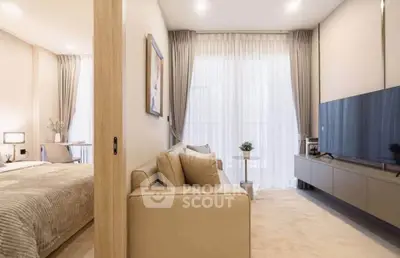 Modern living room with beige sofa, large TV, and elegant decor in a bright apartment.