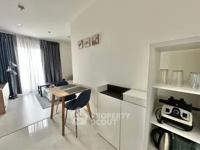 Modern dining area with sleek table and chairs, adjacent to a cozy living space with natural light.