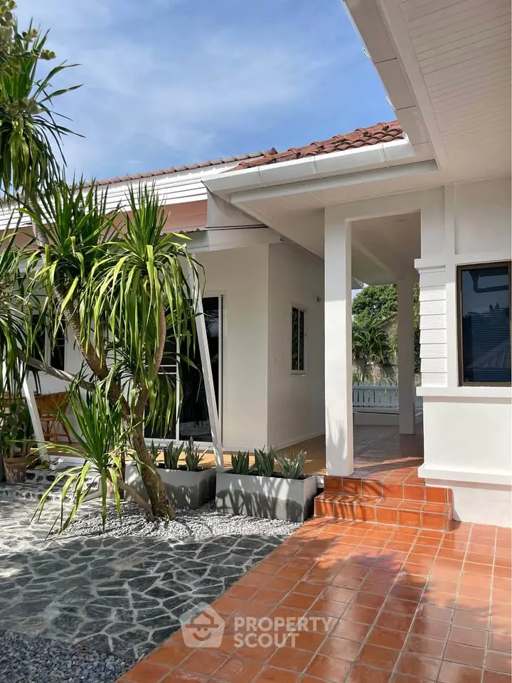 Charming single-story home with terracotta tiles and lush garden, perfect for serene living.